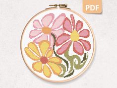 a cross stitch pattern with pink and yellow flowers in the center on a white background