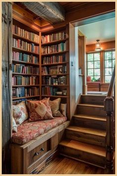 a couch sitting in front of a bookshelf filled with lots of books next to a stair case