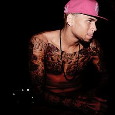 a man with tattoos and a pink hat