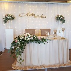 the table is set up for a wedding reception with flowers and candles on it's side