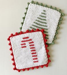 two crocheted christmas coasters sitting next to each other