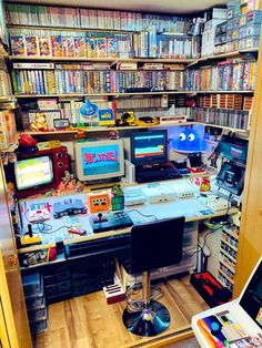 a room filled with lots of different types of electronic devices and bookshelves full of video games