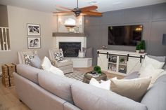 a living room filled with furniture and a flat screen tv mounted on the wall above a fireplace