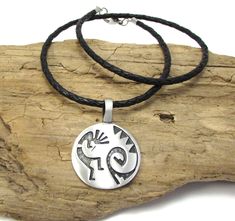 ~ Kokopelli Pendant Necklace. ~ One (1) Domed Round with Kokopelli Pendant (Selected at Random). ~ Color: Antiqued Pewter, ~ Size: 39x28mm Single Sided Kokopelli Pendant, ~ 3mm Braided Leather Cord Necklace, ~ Clasp: Stainless Steel Lobster Claw. ~ Available Colors: 1. Black 2. Antique Brown 3. Dark Brown 4. Saddle Tan 5. Natural 6. Antique Red 7. Black & Red 8. Black & Brown 9. Black & Silver ~ See Photo (9) for colors examples. ~ See Photo (10) to See Size and Back of Pendant. ~ Cr Adjustable Symbolic Stamped Necklace, White Hand-strung Southwestern Necklace, White Southwestern Hand-strung Necklaces, Southwestern Style Nickel-free Necklace For Gift, Kokopelli Mug, Southwestern Brown Hand-strung Jewelry, Bolo Necklace, Braided Leather Necklace, Leather Cord Necklace