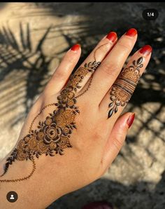 a woman's hand with henna tattoos on it