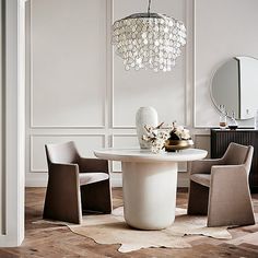 a dining room table with chairs and a chandelier hanging from it's ceiling