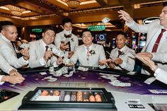 a group of men standing around a casino table with money in their hands and one man holding out his hand