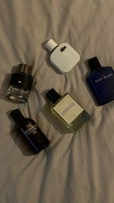 an assortment of perfumes are laid out on a bed