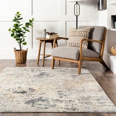 a living room area with a chair, table and potted plant on the floor