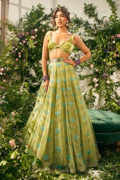 Green attached cancan lehenga with resham embroidery in flower pattern. Paired with bead embellished velvet padded blouse and tassel dupatta.
Components: 3
Pattern: Embroidery, Embellished
Type Of Work: Resham, flower, bead
Neckline: Leaf neck
Sleeve Type: Sleeveless
Fabric: Tulle, Silk Organza, Silk Velvet
Color: Green
Other Details: 
Lehenga Length: 45 inches
Inverted V hem
Back tassel tie-up
Tassel bordered sheer dupatta
Occasion: Wedding - Aza Fashions Flower Lehenga, Neck Flower, Tulle Embroidery, Green Tulle, Silk Tulle, Beaded Neckline, Just Style, Wedding Lehenga, Indian Fashion Designers