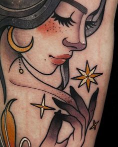 a woman's face with stars and moon tattoos on her arm