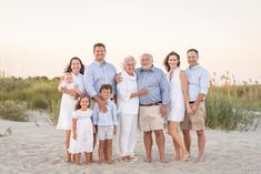 an extended family poses on the beach at sunset