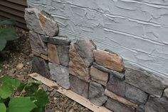 a close up of a stone wall near a house