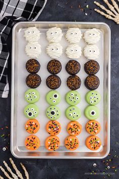 halloween cupcakes decorated with white frosting and sprinkles on a tray