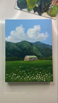 a painting of a house in the middle of a field with mountains and clouds behind it