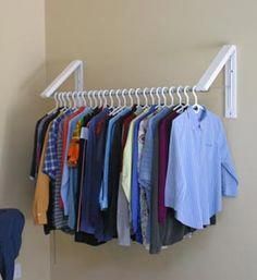 a clothes rack with several shirts hanging on it and a chair in the foreground