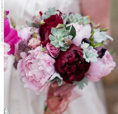 a bride holding a bouquet of pink and red flowers