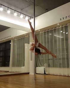 a woman standing on one leg in front of a mirror