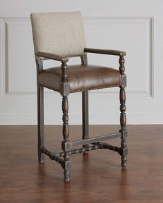 a brown leather chair sitting on top of a wooden floor next to a white wall