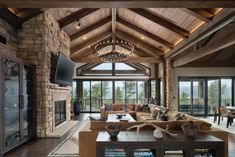 a living room filled with lots of furniture and a fire place in front of a large window