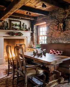 a rustic dining room with stone fireplace and wooden table