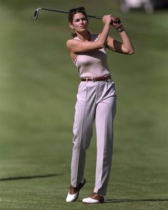 the woman is playing golf on the green