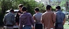 a group of young men standing next to each other in front of an old truck