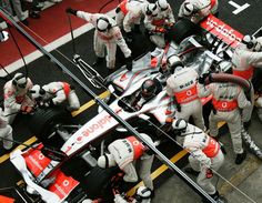 a group of mechanics working on a race car