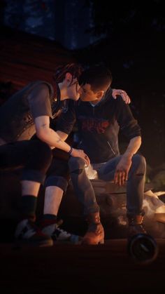 two people sitting next to each other in front of a campfire with their arms around one another