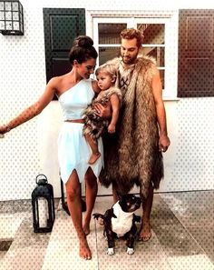 a man, woman and child are dressed up in furry clothes while standing next to a dog