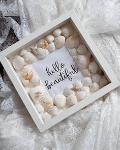 there is a white box with shells in it and the words hello beautiful written inside