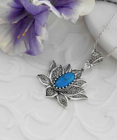 Introducing our handcrafted filigree art blossoming lotus flower figured turquoise gemstone women's 925 sterling silver pendant necklace! This elegant piece features a beautiful turquoise gemstone that is 7.00x14.00 mm, faceted oval cut, and set in a stunning sterling silver filigree lotus flower design. The pendant's height is 1.70 inches and its width is 1.20 inches, and it comes with a silver chain length of 20 inches. The turquoise gemstone is known for its calming and soothing properties, m Elegant Turquoise Flower Pendant Jewelry, Turquoise Sterling Silver Flower Pendant Necklace, Lotus Flower Design, Flower Women, Turquoise Pendant Necklace, Filigree Jewelry, Flower Pendant Necklace, Sterling Silver Filigree, Sterling Silver Necklace Pendants