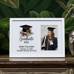 a graduation photo frame with a graduate's cap and tassel on the mantle