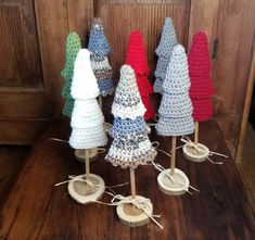 small crocheted christmas trees on wooden stand