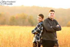 a man and woman standing in tall grass