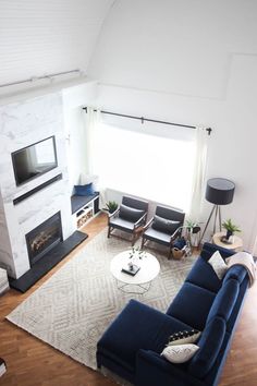 a living room filled with furniture and a flat screen tv mounted on the wall above a fireplace