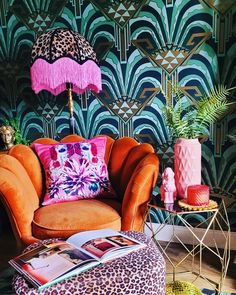 a living room with an orange chair, leopard print ottoman and pink lampshade