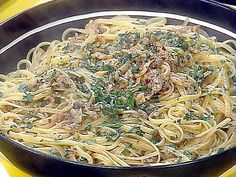 pasta with meat and spinach in a pan on a yellow tablecloth, ready to be eaten