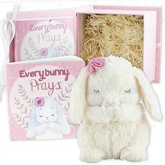 a white stuffed rabbit sitting next to a pink box