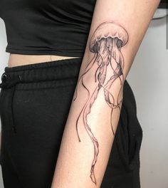 a woman's arm with a jellyfish tattoo on the left side of her body