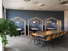 an empty conference room with wooden tables and chairs in front of blue walls that have hexagonal cutouts on them