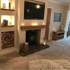 a living room filled with furniture and a flat screen tv mounted on the wall above a fire place