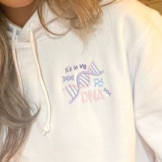 a close up of a person wearing a white hoodie with the words, it's in my dna on it