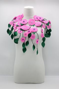 a white mannequin with pink flowers and green leaves on it's chest