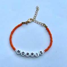 an orange beaded bracelet with the word norris written in white letters on it