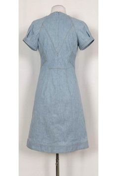 Versatile denim dress featuring a classic semi flared silhouette. The perfect dress to wear to a picnic at the park, pair it with chic sandals and a statement handbag. Size 4 Lined, cotton & elastane blend V-neckline Short sleeves Unlined Flared silhouette Mustard top stitching Above knee Bust 34" Waist 28" Shoulder to hem 37" Knee-length Denim Dress For Summer Workwear, Summer Knee-length Denim Dress For Work, Fitted A-line Denim Dress For Summer, Fitted Cotton Denim Dress For Summer, Summer Short Sleeve Fitted Denim Dress, Fitted Short Sleeve Denim Dress For Summer, Chic Mid-length Cotton Denim Dress, Elegant Summer Denim Dress For Workwear, Fitted Midi-length Denim Dress For Spring