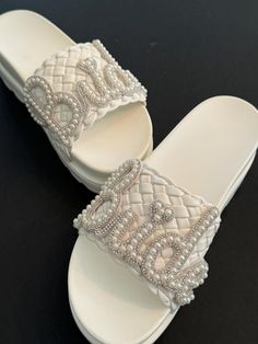 All Leather Bridal slip on slide Platform sandals. Custom made with silver and pearl "Bride " lettering along wide leather strap. These are Soooo comfy. Perfect for throwing off heels to wear at reception. Wedged to 3 inches !!   Great Gift idea for bachelorette parties, Showers, Engagement parties, Honeymoon..  Rush orders are welcome for a quick next day shipping! Exchanges and Refunds are offered. Contact Audrey for questions 24/7 . Custom ideas are always welcome if you have something else in mind.. White Pearl Open Toe Wedding Shoes, White Pearl Wedding Shoes For Summer, Summer Pearl White Wedding Shoes, Silver Open Toe Wedding Shoes For Bridal Shower, Bride Sandals, Bridal Flip Flops, Beach Wedding Shoes, Sandals Wedding, Pearl Bride