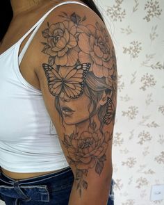 a woman with flowers and butterflies on her shoulder