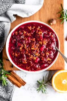 a white bowl filled with cranberry sauce on top of a wooden cutting board