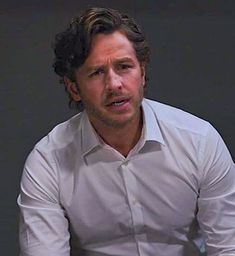 a man in a white shirt sitting down